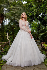 Fototapeta premium Sexy beautiful woman pretty bride wedding big day marriage ceremony in summer garden wearing long silk and lace white dress bright makeup hairstyle pure love.