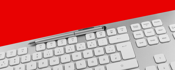 Keyboard and pen against red background
