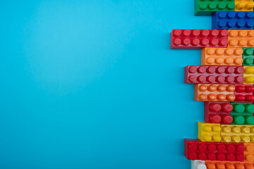 Wall from Plastic building blocks isolated on blue background. Top view 