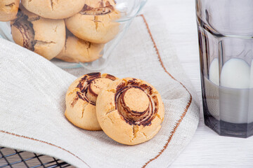 Several champignon cookies on white with a glass with milk