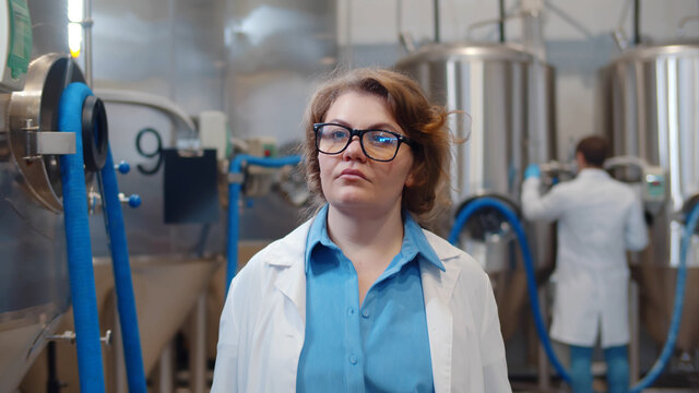 Portrait Of Confident Female Scientist In Lab Coat Walking In Modern Beer Factory