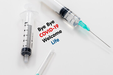 bye bye coronavirus welcome life inscription in the middle of syringes on a white background