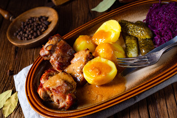 Rustic Snirtjebraten with red cabbage and cucumber