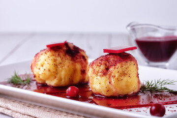 Swedish potato dumplings with cranberry sauce on a light background