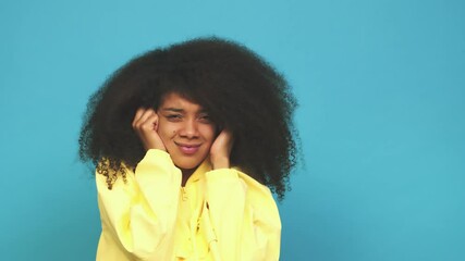Young african american curly woman covering ears with hands