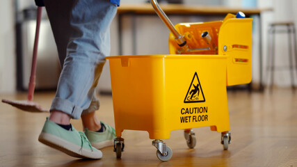 Fototapeta premium Close up of cleaner pushing bucket with detergent in private apartment