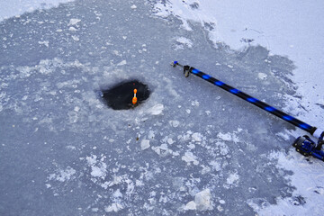 Hole for winter fishing in the ice on the river