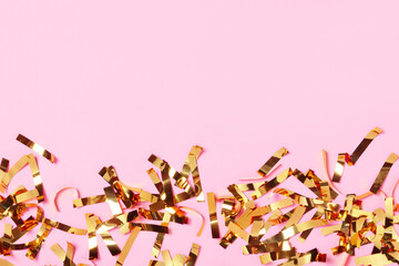 Gold confetti on pink background. Top view. Celebration background.