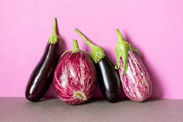 Still life with ripe violet aubergine on purple background. Different types of eggplant with unique...