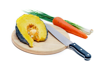 Vegetables and knife on cutting board on white kitchen countertops. Preparing food on white table
