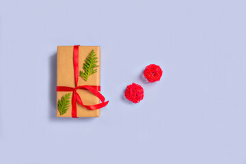 Gift boxes wrapped with paper kraft, red ribbon, thuja twigs, balls on a light background. Top view. Presents for the holiday, Christmas.