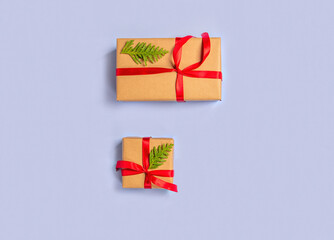 Gift boxes wrapped with paper kraft, red ribbon, thuja twigson a light background. Top view. Presents for the holiday, Christmas.