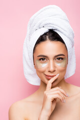 smiling beautiful woman with towel on hair and hydrogel eye patches on face isolated on pink