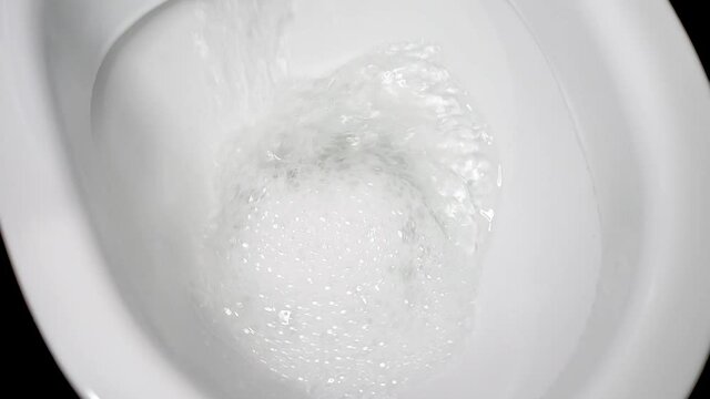 Flush the toilet close-up. White clean toilet, flushing water large