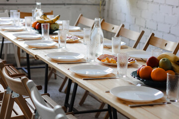 Table served for holiday dinner in living room in loft style, close up view