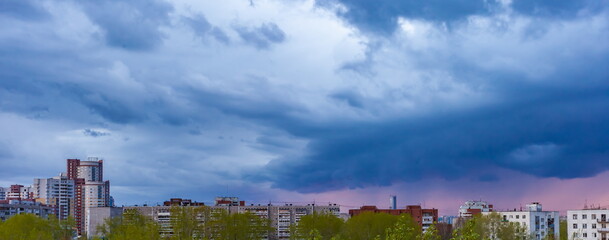 Fototapeta premium Cloud over the city at sunset in summer