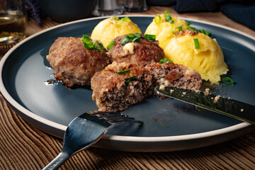 Meatballs with cheese served with boiled potatoes.