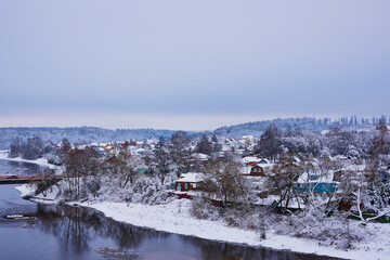  A snow-covered village on the Bank of a river .