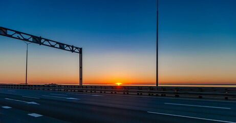 Sunset on the highway in the summer against the clear sky