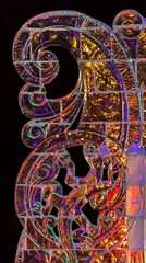 Fragment of an ice sculpture illuminated at night in winter