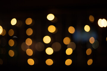 Several strands of Christmas and New Year golden garlands on a black background. Bokeh style, soft focus. Blurred background.
