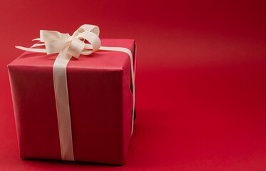 Gift red box with ribbon on a bright background. Place for text