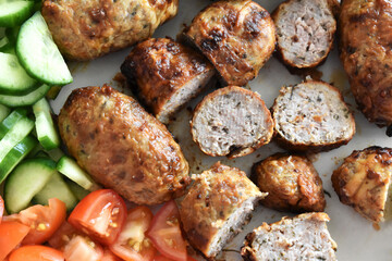 Sheftalia: Cypriot Lamb and Pork Sausages.  Grilled Sausages with Fresh Vegetables (Cucumber and Tomato) on a White Plate. Traditional Cypriot food. 