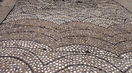 Stones laid on the footpath in the Park in summer. Focus in the center