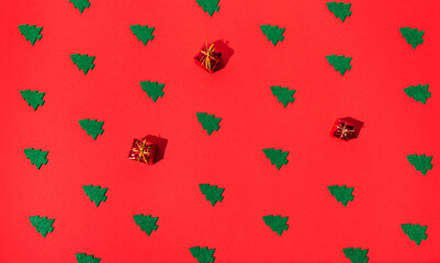 Winter composition  of green christmas trees on red background.