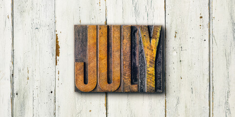 Antique letterpress wood type printing blocks on a white backgound - July