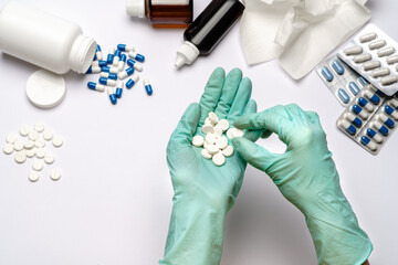 close up doctor hand in a latex glove holding tablets over light grey or white background with medical suppliements