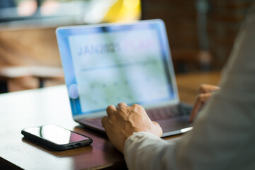 Close up of a businessman looking at new year 2021 planner on laptop screen to plan his business...