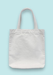 Tote bag mockup, white blank cotton fabric canvas cloth for eco shoulder shopping sack mock up template isolated on pastel blue background (clipping path)