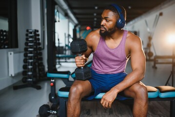 healthy african man working out with dumbbells in gym