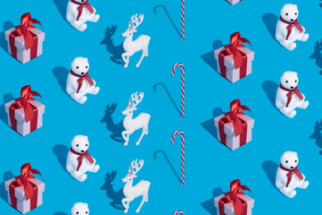 Christmas pattern made with polar bear, red gift box and reindeer on vibrant blue background. Minimal New Year festive celebration concept. Flat lay, top view.
