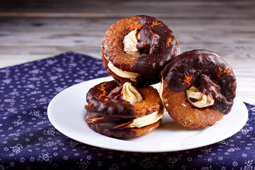 Three yummy homemade chocolate covered marshmallow crackers on white plate on a purple napkin