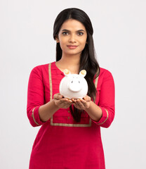 Fototapeta na wymiar Young Woman Saves Money in Piggy bank on white