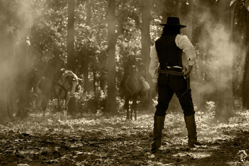 Obraz premium Vintage portrait of three cowboy men riding a gunfighting horse. In a forest