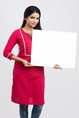 Cheerful attractive young women holding white board and showing thumbs up on white.