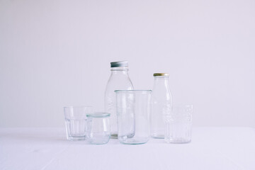 Set of empty bottles and jars on the top of a table with white background