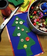 green felt tree on corrugated paper with scissors and beads