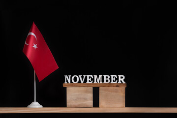 Wooden calendar of November with Turkish flag on black background. Holidays of Turkey in November