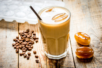 cold coffee glass with ice cubes on wooden table background