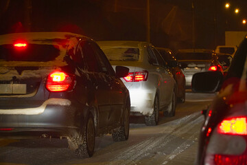 Cars in traffic in winter in the evening dark or at night