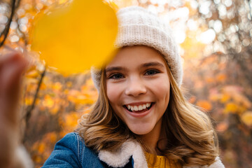 Positive girl walking outdoors in autumn park