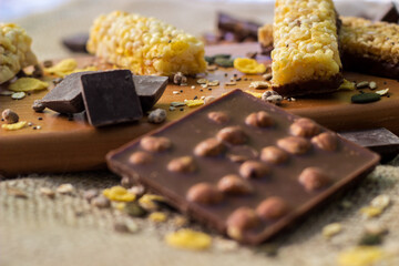Granola Bars and mixed nuts. Honey bars with peanuts, chocolate, dried fruit, sesame and sunflower seeds