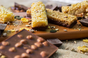Granola Bars and mixed nuts. Honey bars with peanuts, chocolate, dried fruit, sesame and sunflower seeds