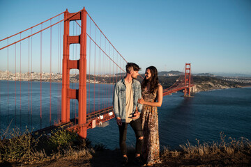 couple standing in front of the golden gate bridge in san francisco