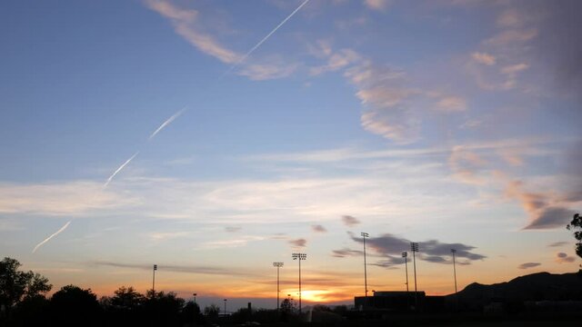 Sunset over athletics field lights