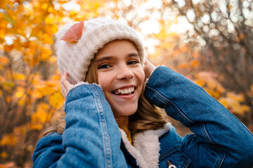 Happy girl walking outdoors in autumn park